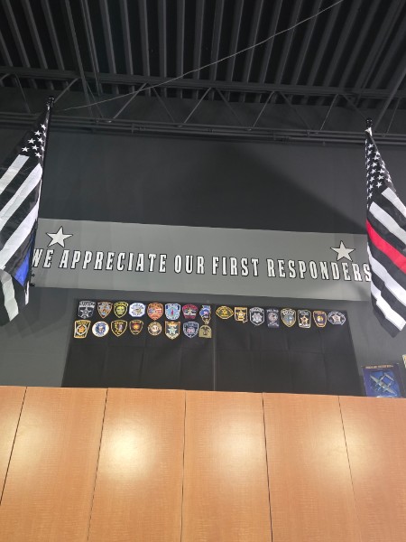 Thin blue line and thin red line flags above a display honoring local first responders inside Men and Boys Haircuts