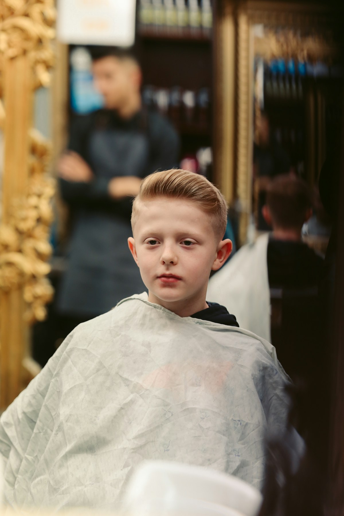 A young boy smiling during a haircut