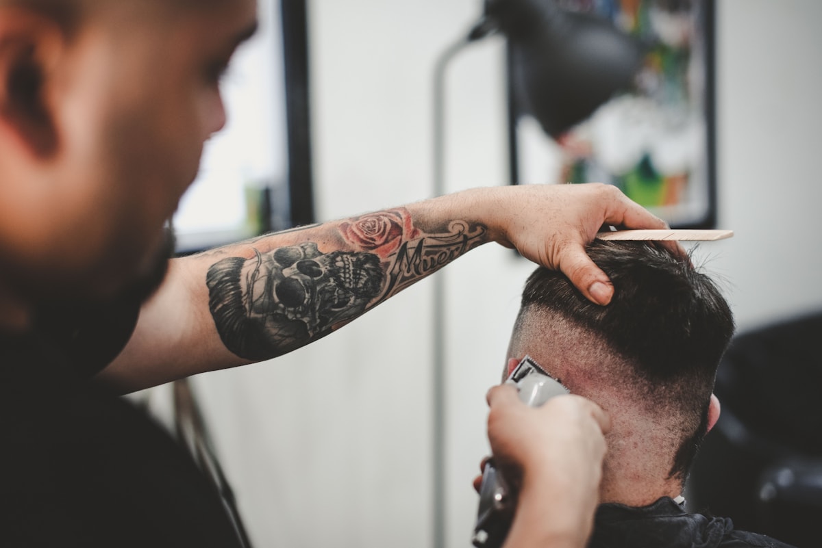 A barber shaping a clean fade with clippers