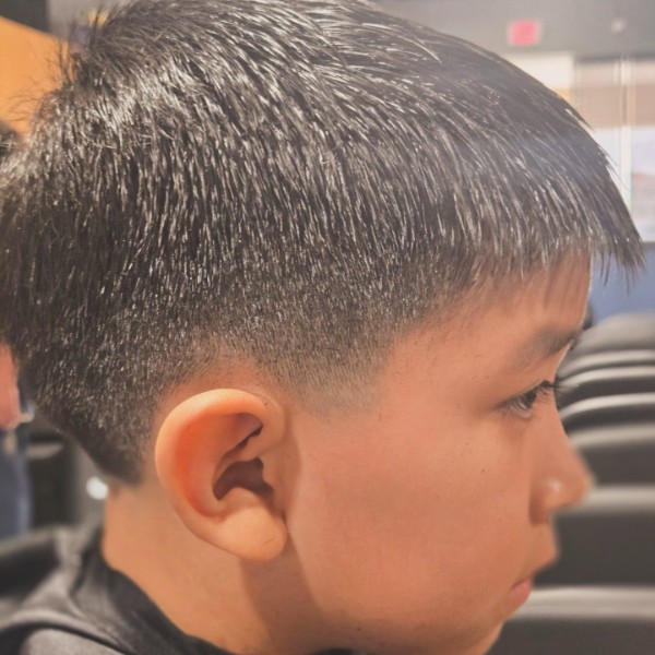 Profile view of a kids adventure cut with a neat fringe and blended sides