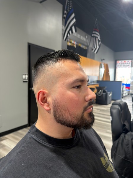 Side view of a finished modern fade with a textured top and shaped beard