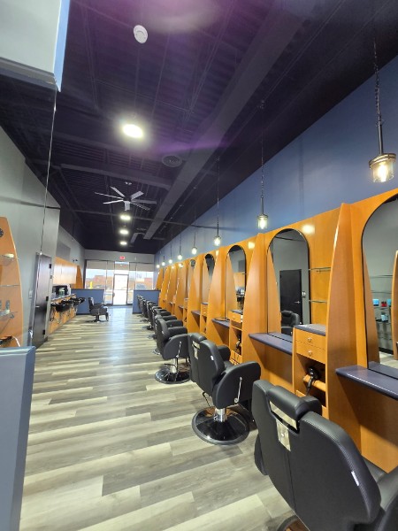 A bright row of barber chairs and styling stations inside the salon