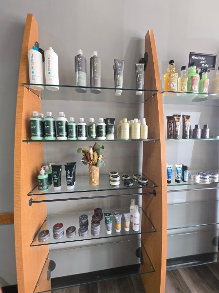 Professional hair and grooming products displayed on glass shelves